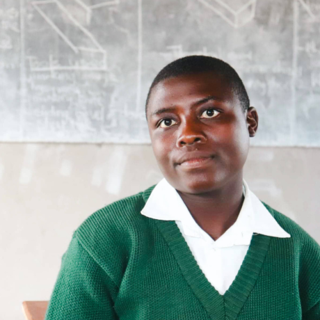 Yollanda sitting in the classroom of her school